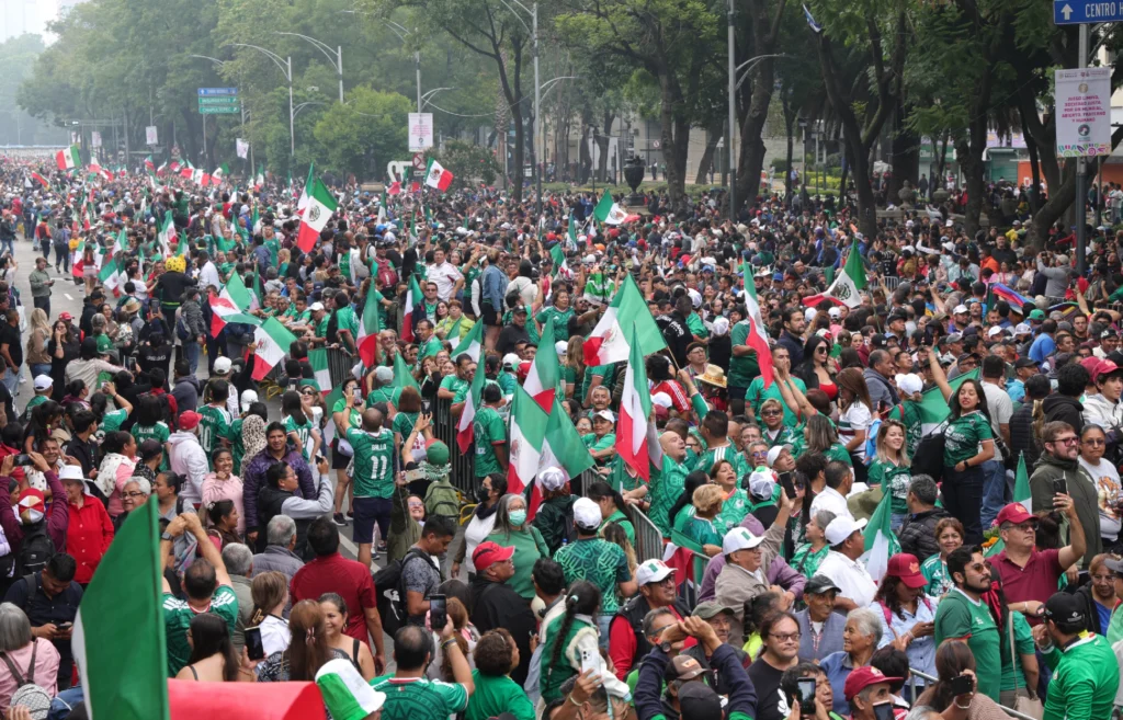 Aficionados mexicanos observan un partido de futbol mientras analizan el impacto económico del torneo internacional de selecciones en México.